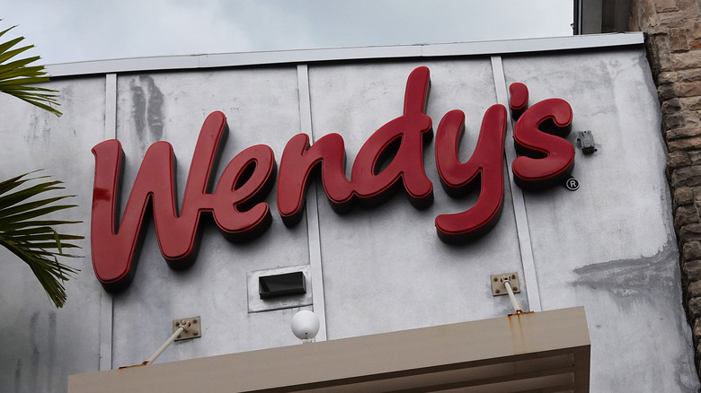 Wendy's sign on wall with palm trees