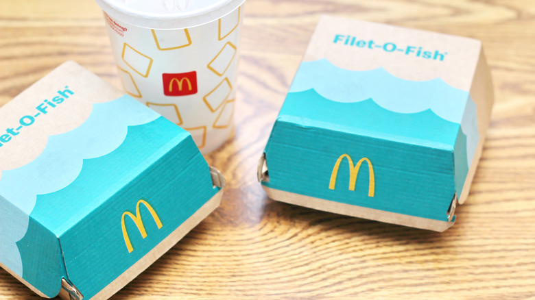 two filet-o-fish boxes with a soda on a table