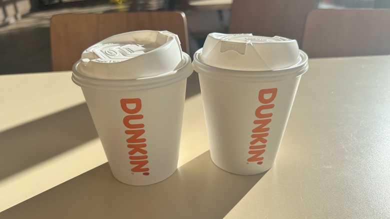 Two Dunkin' cups on a table