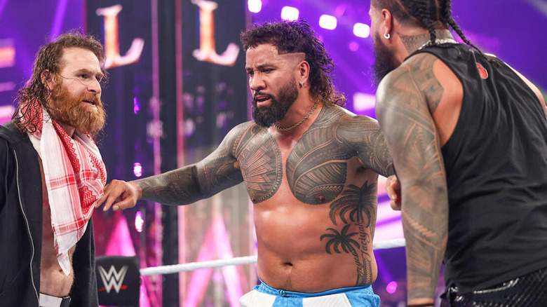 Jey Uso stands between Jimmy Uso and Sami Zayn